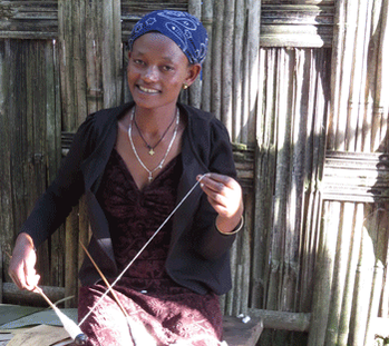 A Dorze woman spins cotton thread.